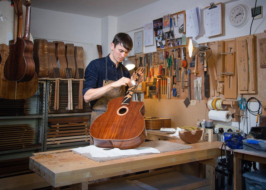 Alex Bishop working on a guitar in a workshop